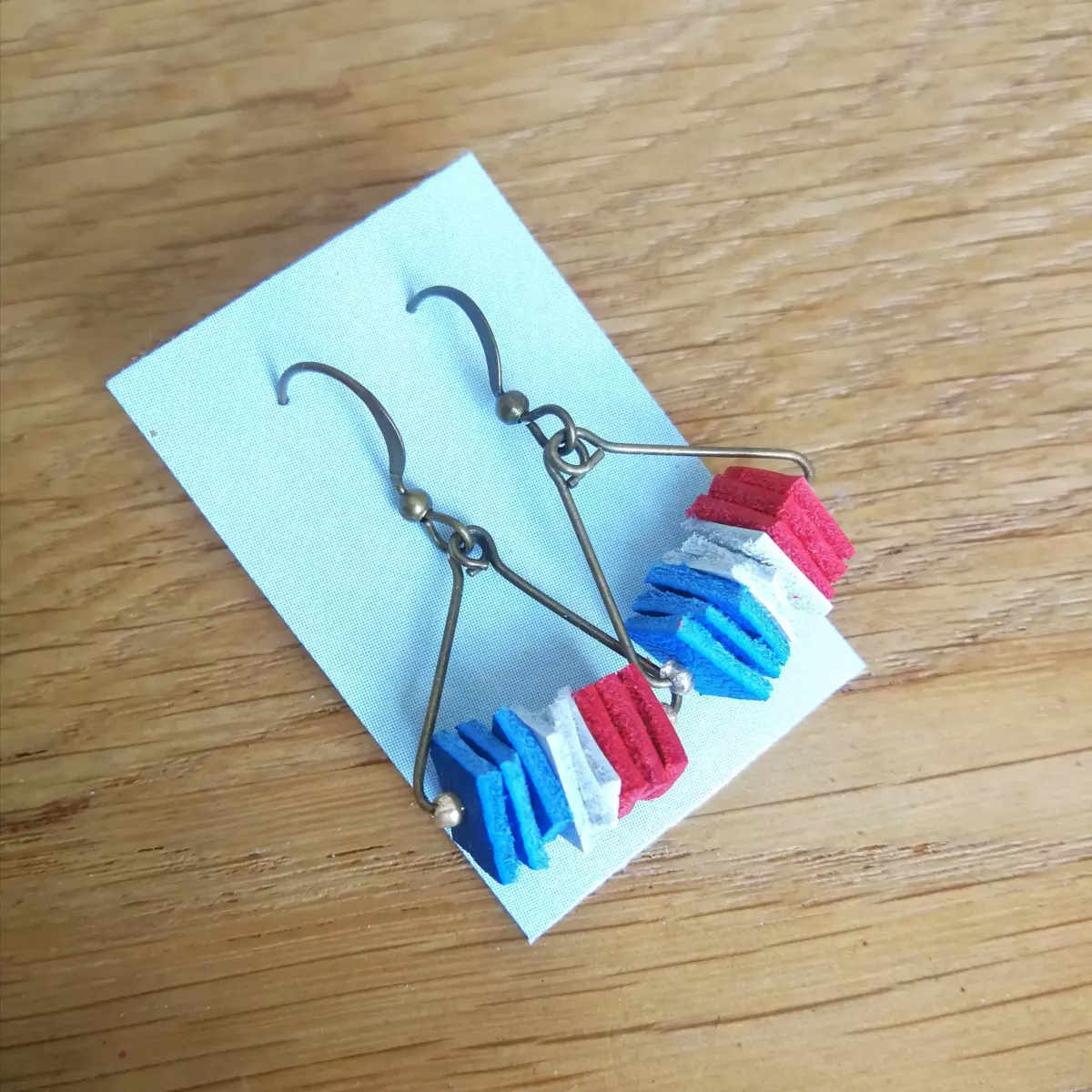 Boucles d'oreilles en cuir surcyclé bleu blanc rouge créées sur mesure par L'Artelier de Cloth pour Gaëlle Edon, athlète en paratir à Paris 2024. Portées dans le public lorsqu'elle assistait aux épreuves de Tanguy de la Forest.